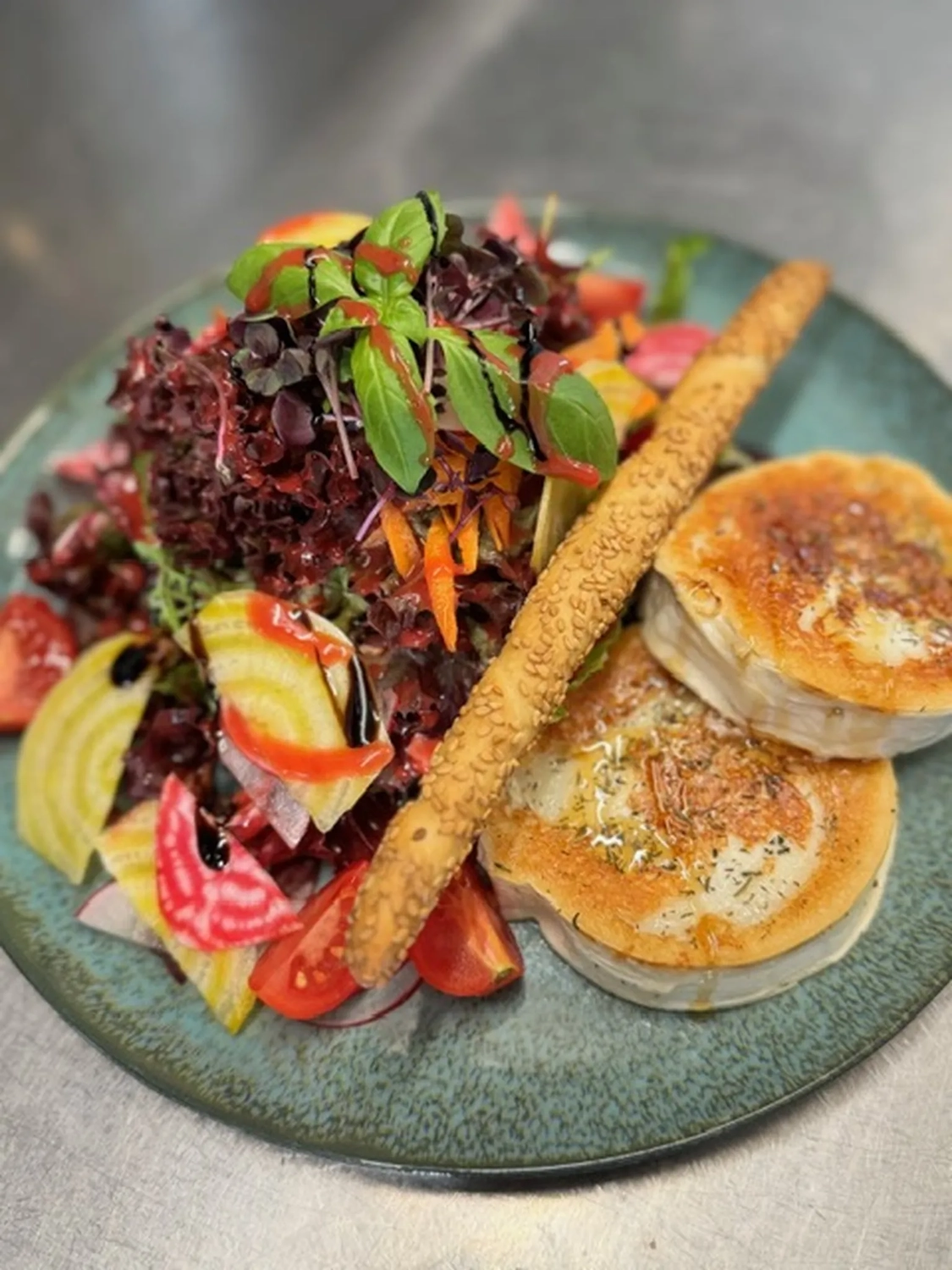 Bistro Maximilian -  Gastronomie - Salat mit gebratenem Ziegenkäse und einem Sesam-Brotstängel.