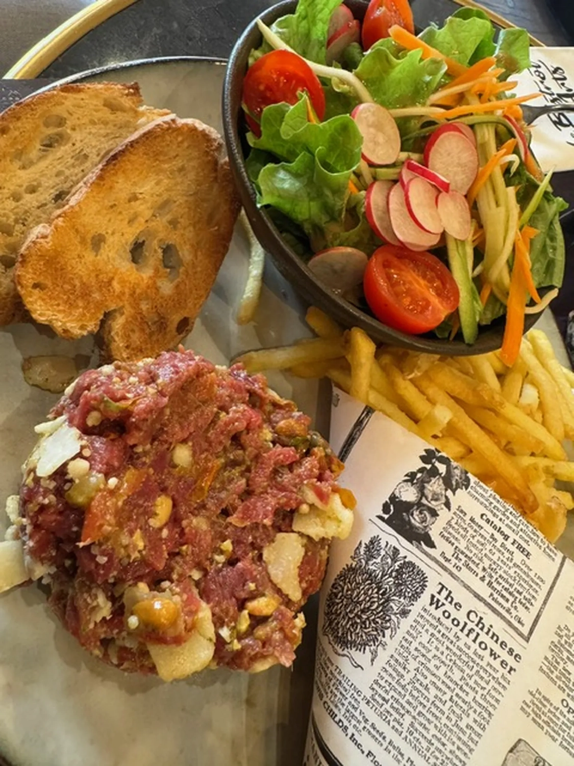 Bistro Maximilian -  Gastronomie - Steak Tatar, serviert mit Beilagensalat und Pommes frites